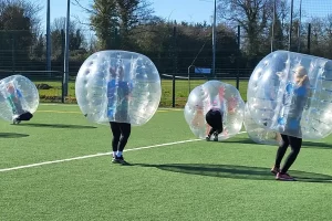 A group of colleagues playing a game of bubble football for their team away day