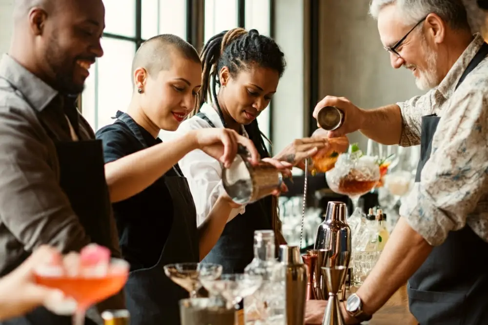 A group of 4 adults taking part in a cocktail making class